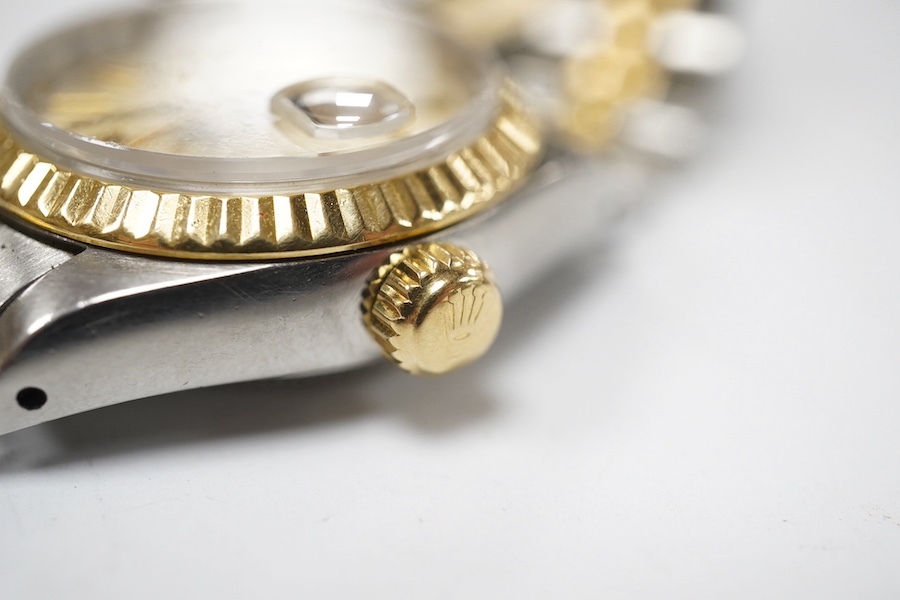 A lady's late 1980's steel and gold Rolex Oyster Perpetual Datejust wrist watch, with baton numerals, serial no. 9773085, on a steel and gold Rolex bracelet, no box or papers. Condition - poor to fair